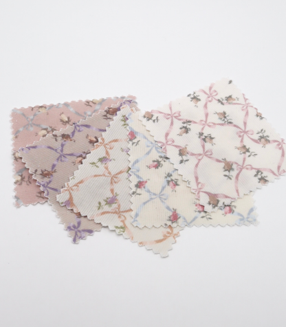 ローズ×リボンプリントコーデュロイ生地布のクローズアップ画像。可愛らしいバラとリボンのプリント柄が特徴的なコーデュロイ素材で、犬服用やバッグ用の手芸に最適な布地