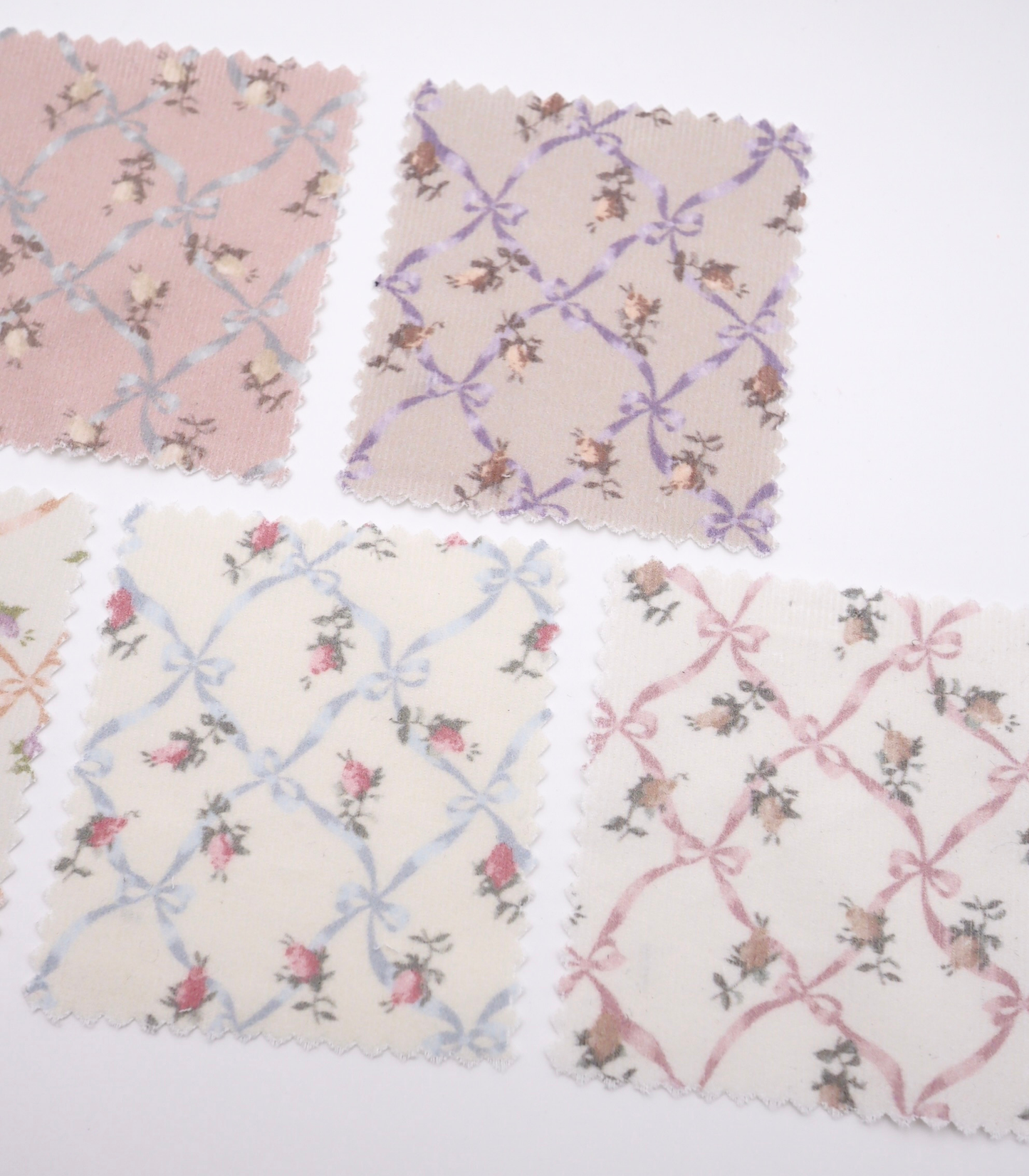 ローズ×リボンプリントコーデュロイ生地布のクローズアップ画像。可愛らしいバラとリボンのプリント柄が特徴的なコーデュロイ素材で、犬服用やバッグ用の手芸に最適な布地