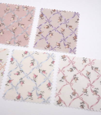 ローズ×リボンプリントコーデュロイ生地布のクローズアップ画像。可愛らしいバラとリボンのプリント柄が特徴的なコーデュロイ素材で、犬服用やバッグ用の手芸に最適な布地