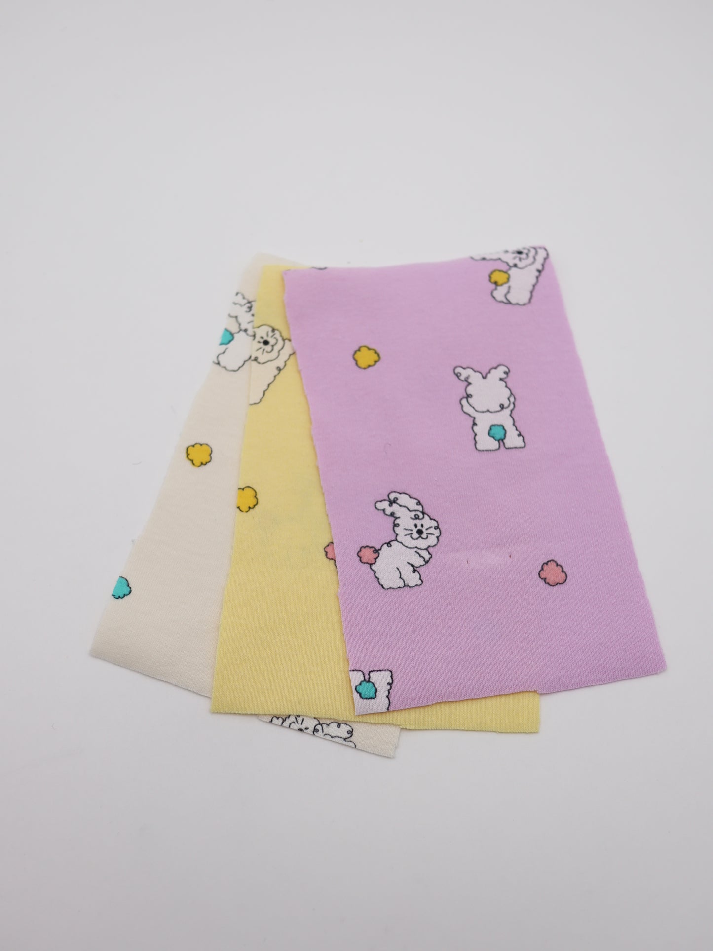 カラフルしっぽウサちゃんプリント・綿ベア天竺｜152cm超広幅・PU5%混・ストレッチ・薄手・高意匠・低刺激｜ドッグウェア・子供服・ロンパース向き｜26SS-081【生地仕入れ代行卸】