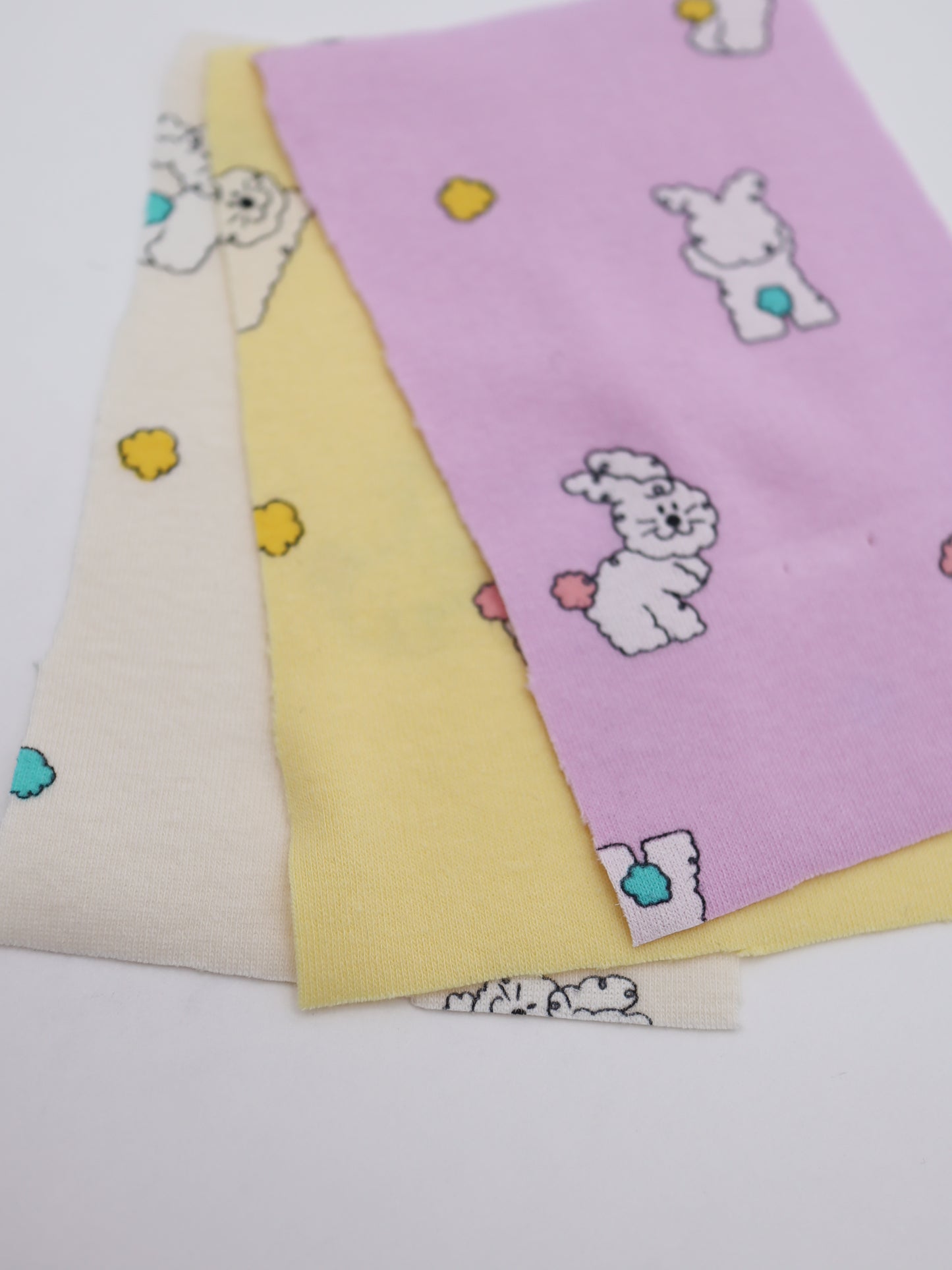 カラフルしっぽウサちゃんプリント・綿ベア天竺｜152cm超広幅・PU5%混・ストレッチ・薄手・高意匠・低刺激｜ドッグウェア・子供服・ロンパース向き｜26SS-081【生地仕入れ代行卸】