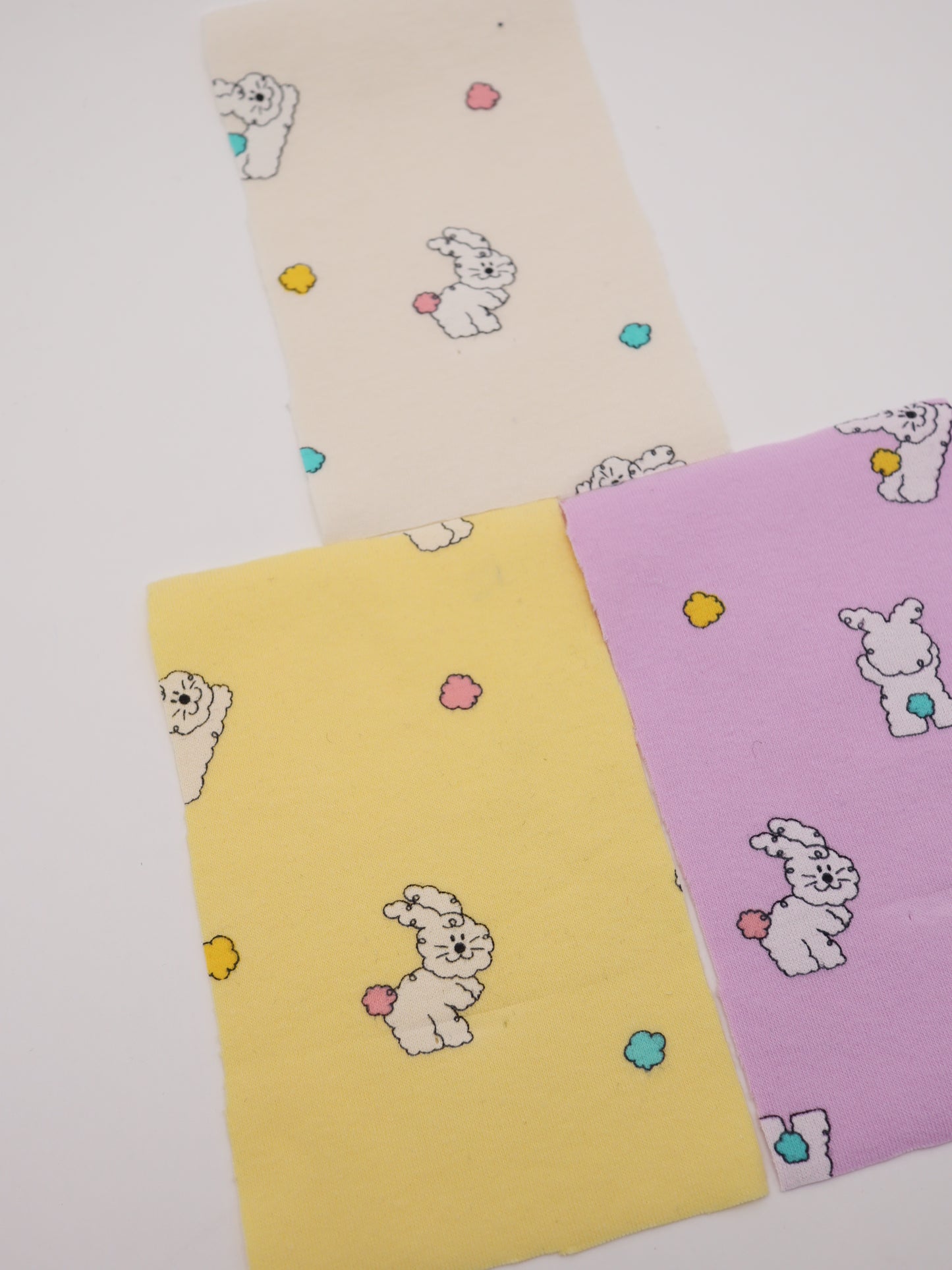 カラフルしっぽウサちゃんプリント・綿ベア天竺｜152cm超広幅・PU5%混・ストレッチ・薄手・高意匠・低刺激｜ドッグウェア・子供服・ロンパース向き｜26SS-081【生地仕入れ代行卸】