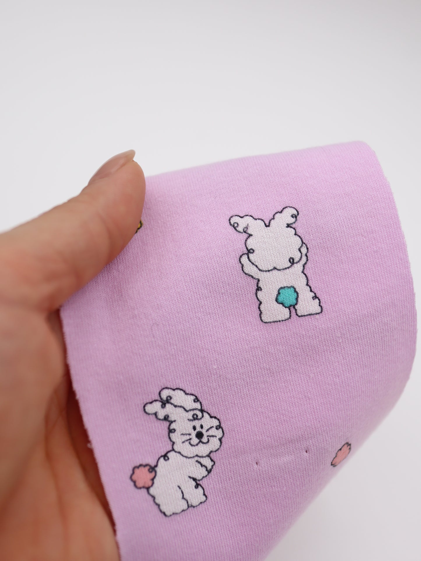 カラフルしっぽウサちゃんプリント・綿ベア天竺｜152cm超広幅・PU5%混・ストレッチ・薄手・高意匠・低刺激｜ドッグウェア・子供服・ロンパース向き｜26SS-081【生地仕入れ代行卸】