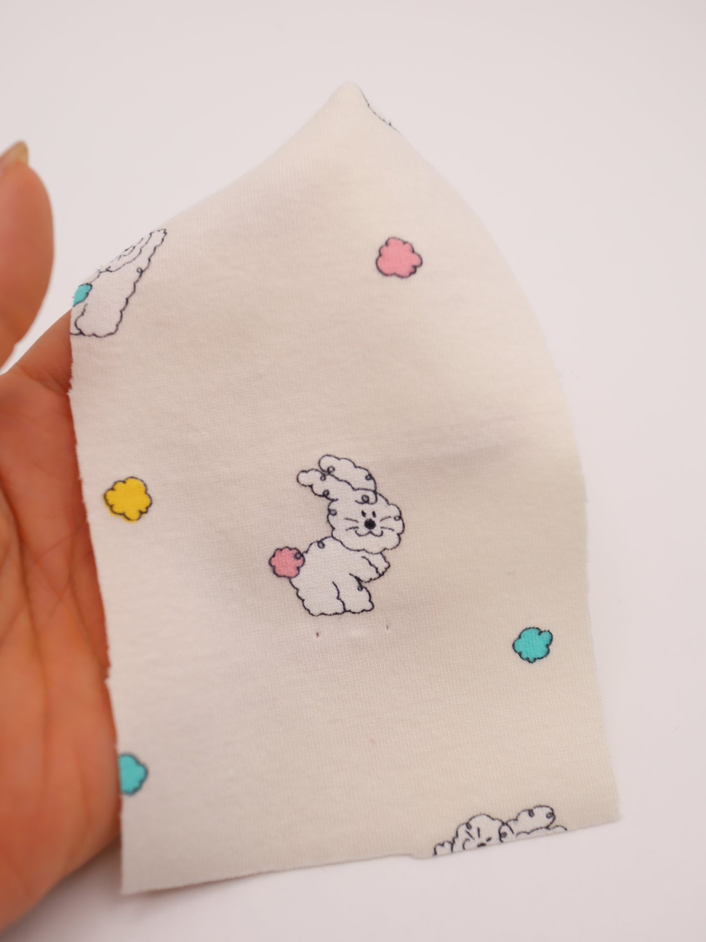 カラフルしっぽウサちゃんプリント・綿ベア天竺｜152cm超広幅・PU5%混・ストレッチ・薄手・高意匠・低刺激｜ドッグウェア・子供服・ロンパース向き｜26SS-081【生地仕入れ代行卸】